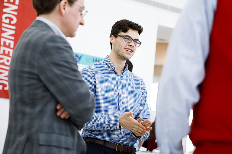 A student speaks with potential employers at a career event.