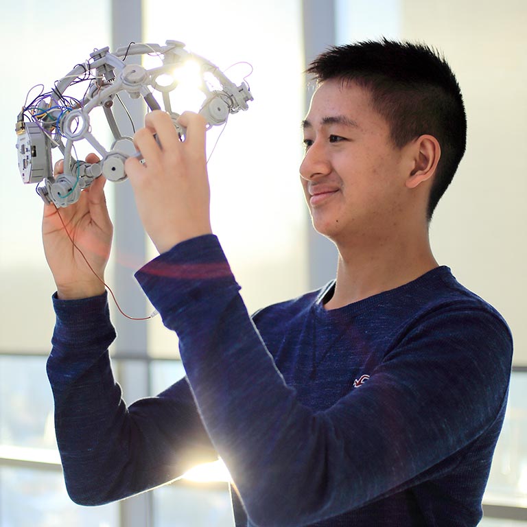 A student looks at a digital device designed to wear on the head.