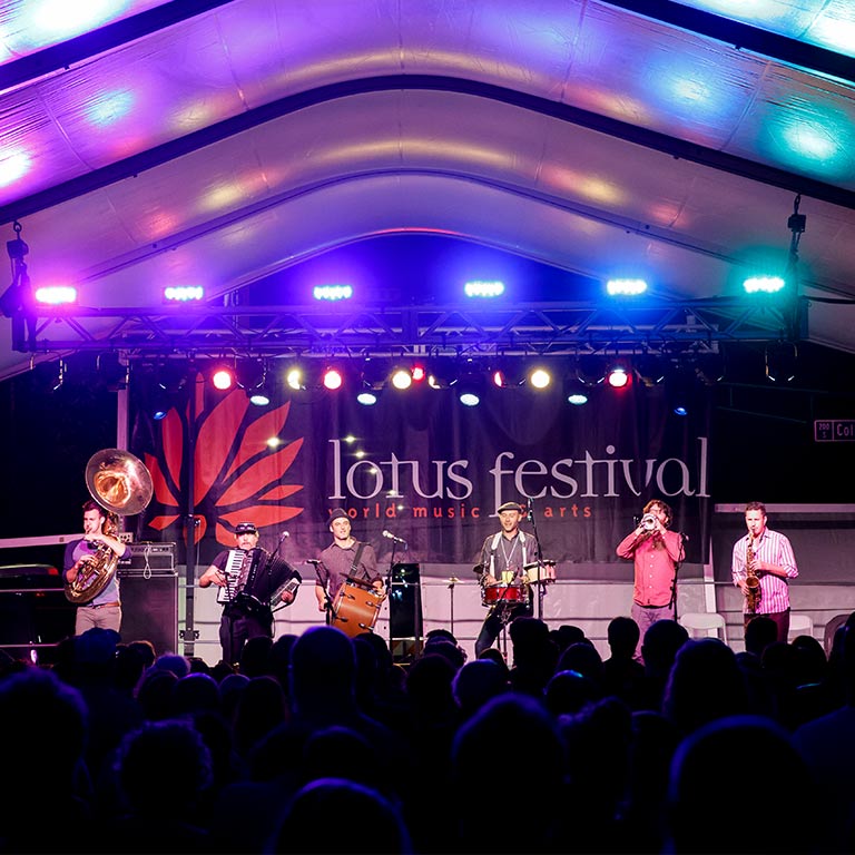 A group of musicians plays on stage at Lotus Festival in Bloomington Indiana.